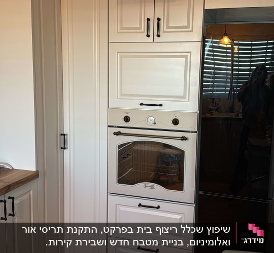 תנור בילט-אין לבן עם ידיות שחורות במטבח מודרני